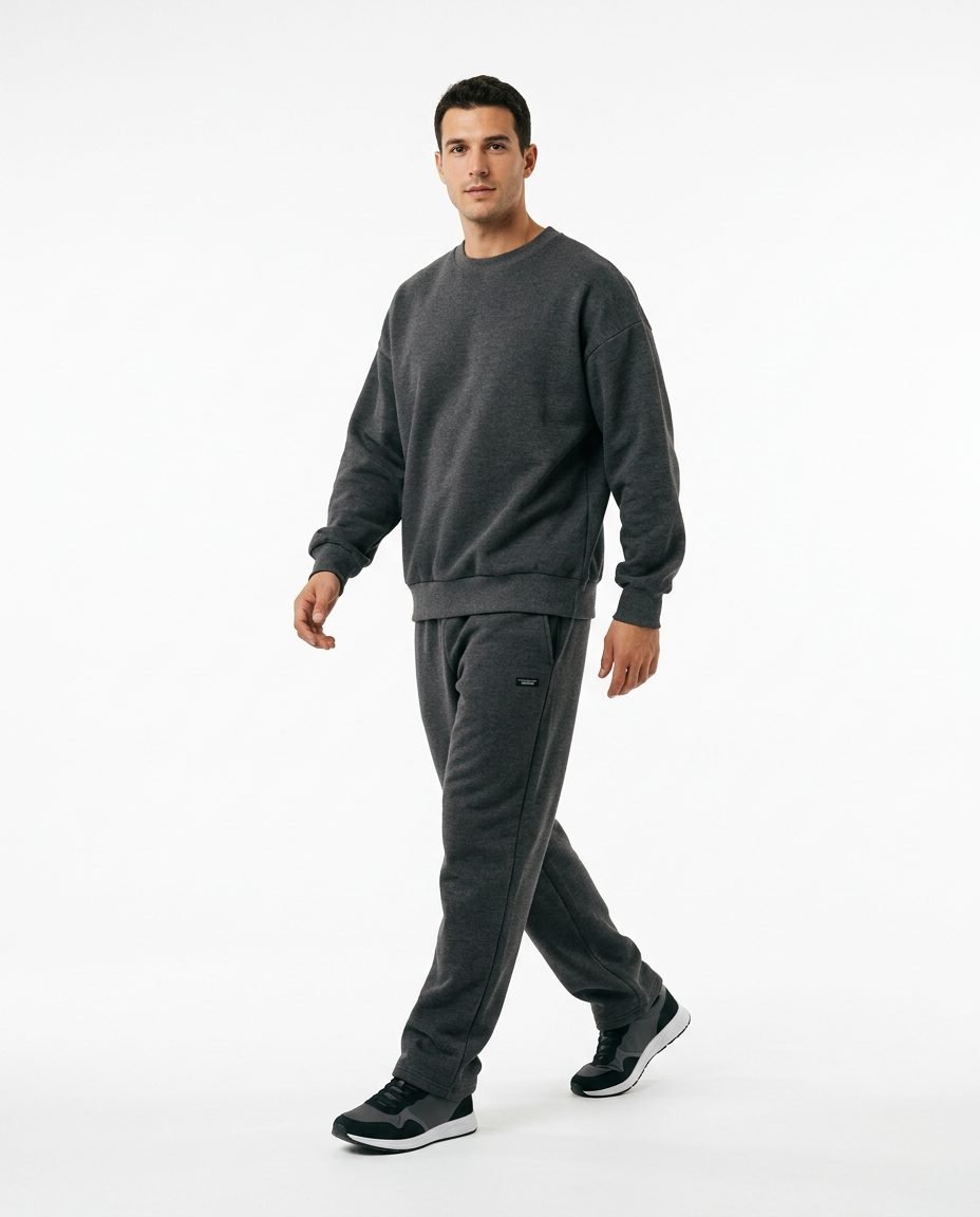 Modelo caminando con conjunto gris sobre fondo blanco